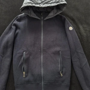 Moncler cardigan - Riktigt fet moncler cardigan i halvbra skick. Lite defekter som man ser på bilderna. Finns inga fler defekter än det och det mesta går nog att fixa. 2599kr. Storlek xs. 