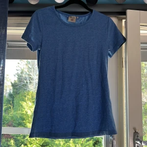 Blå t-shirt från Tribute - Säljer en snygg blå t-shirt från Tribute i storlek S. Den är i bomull och har en normal passform med korta ärmar. Perfekt för vardagsbruk eller sommarens äventyr. T-shirten är i mycket bra skick och redo för en ny ägare!