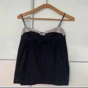 Svart axelbandslös topp - Snygg svart axelbandslös topp med smala axelband och glitter. Kör på Vinted aldrig använd av mig 💗