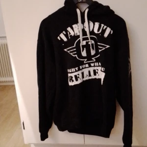 Hoodie Från Tapout - Svart hoodie från tapout i storlek xl. Ser ganska sliten ut och är troligen de då jag köpte den på loppis.  Katt finns I hemmet