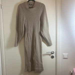 Beige ribbad klänning - Säljer en superfin beige ribbad klänning med långa ärmar. Perfekt för höst och vinter, den är både stilren och bekväm. Klänningen har en normal passform och är gjord i ett mjukt material som håller dig varm. Passar perfekt till både vardag och fest!
