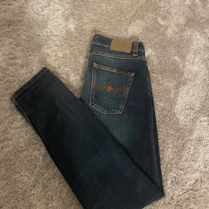 Mörkblå jeans från Nudie Jeans - Säljer ett par snygga mörkblå jeans från Nudie lean dean Jeans i storlek W29 L30, snygg passform utan några defekter. Använda max två gånger. Nypris 1599, hör av dig vid eventuella frågor och funderingar.