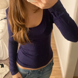 Mörkblå långärmad topp - Säljer en snygg mörkblå långärmad topp i ett mjukt och stretchigt material. Perfekt för både vardag och fest! Toppen har en rundad halsringning och sitter tight för en smickrande passform. Passar perfekt till jeans eller kjol.