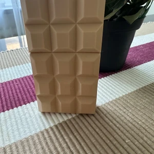 Sweet Tooth parfym av Sabrina Carpenter - Säljer en unik parfym som heter Sweet Tooth av Sabrina Carpenter. Flaskan är formad som en chokladkaka i en beige nyans, vilket ger den en söt och lekfull stil. Perfekt för dig som älskar både doft och design!