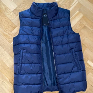 Mörkblå dunväst  - Säljer en snygg mörkblå dunväst i storlek S. 