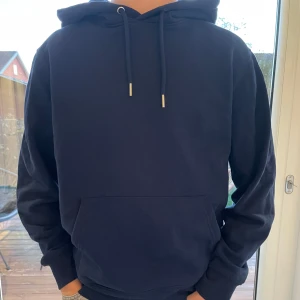 Svart hoodie med tryck - Säljer en mörkblå hoodie från Mi Amor. Den är nästintill nytt skick och bara använd ett fåtal gånger. Storlek XS (TTS). Skriv vid minsta lilla fråga!