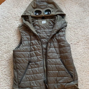C.P. Company grå/grön väst - Säljer en olivgrön/grå väst från C.P. Company. Västen är i bra skick (No flaws). Strl: 50 (M/L) Slutsåld överallt, byten kan vara intressant