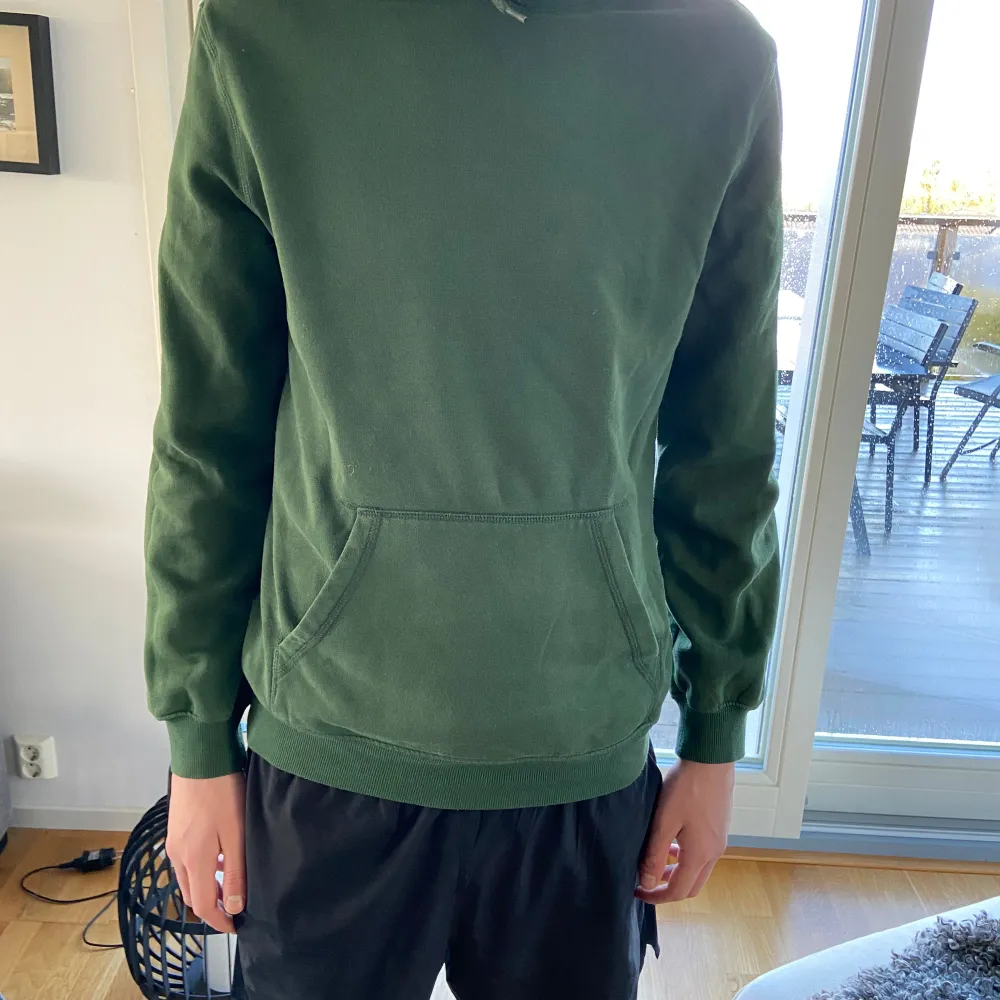 Säljer en grön hoodie från H&M i storlek M. Den har en avslappnad passform och en praktisk magficka. Perfekt för höst och vår, och den är superbekväm att ha på sig. Passar både för chill hemma och ute på stan. 🟢. Tröjor & Koftor.