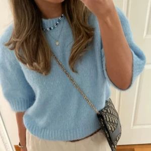 Ljusblå stickad T-shirt tröja - Säljer en superfin ljusblå stickad tröja med trekvartsärm från vero Moda . Perfekt nu till vintern, då den är både mysig och stilren. Tröjan har en mjuk och fluffig textur som gör den extra bekväm att bära. ❤️