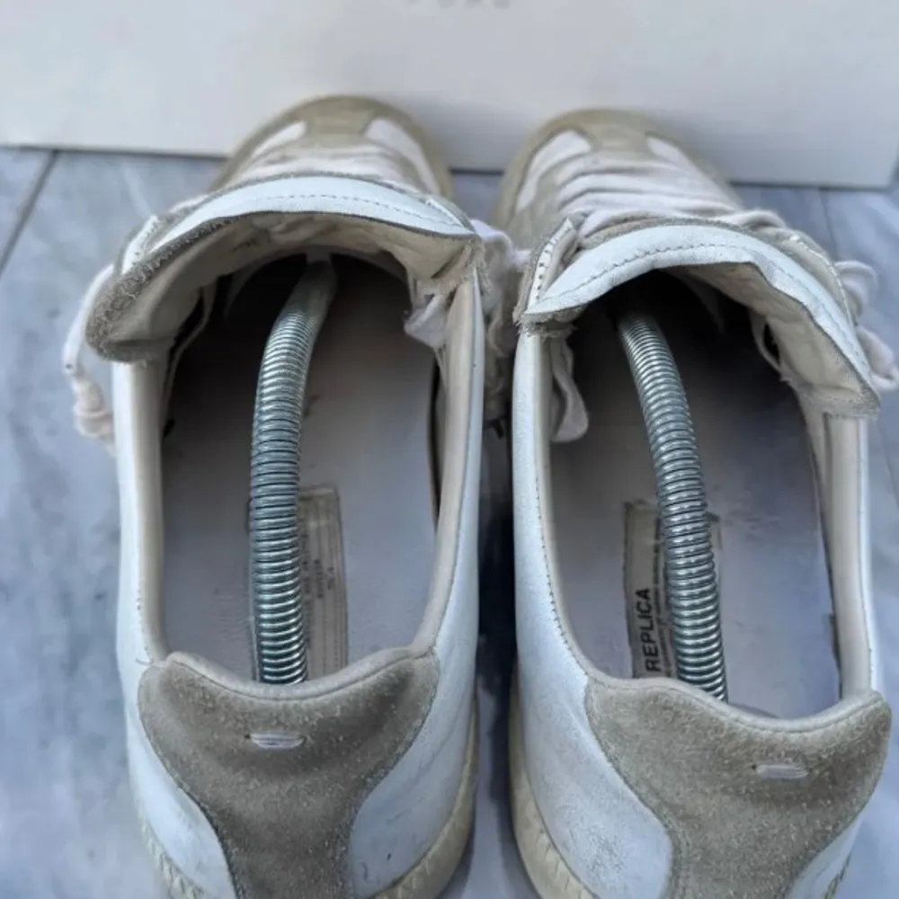 Säljer ett par stilrena Maison Margiela sneakers i beige och vit färg. Skorna är gjorda i en kombination av mocka och skinn, vilket ger dem en lyxig känsla. De har klassisk snörning och är i mycket bra skick. Perfekta för både vardag och fest!   storlek 43 så ch Dustbag kommer med. Skriv om frågor och om ni vill köpa. Kom med prisförslag.  Tänker mig runt 3000. De är legit checkade och är såklart äkta!jag kommer inte gå med prisförslag som är helt orimliga!. Skor.