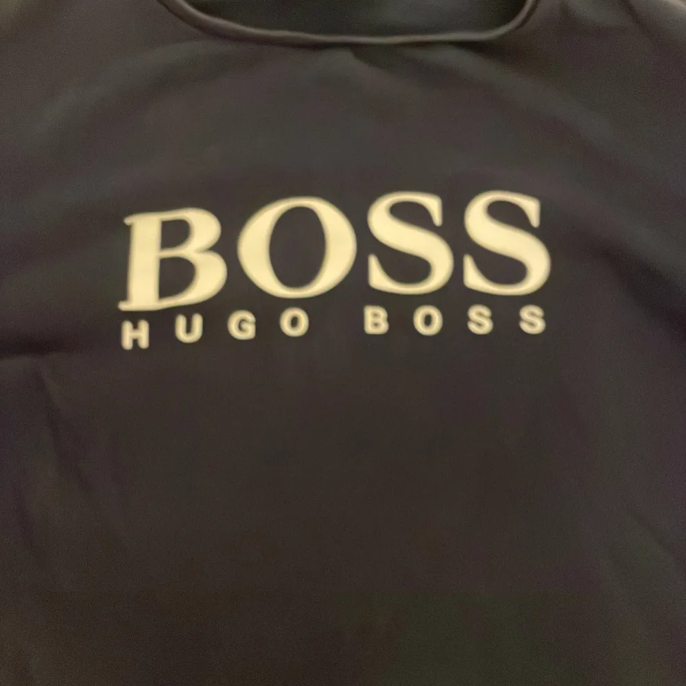 Säljer en stilren svart långärmad tröja från Hugo Boss. Perfekt för både vardag och lite finare tillfällen. Tröjan har en klassisk design med loggan tryckt i vitt på bröstet. Superbekväm och lätt att matcha med olika outfits!. Tröjor & Koftor.