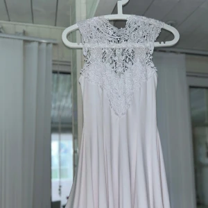 Vit klänning med spetsdetaljer - Säljer en superfin vit klänning med vackra spetsdetaljer upptill. Klänningen är ärmlös och har en luftig passform som gör den perfekt för sommarens alla fester. Den har en elegant och romantisk stil med en öppen rygg som ger en extra touch. Perfekt för midsommar eller en somrig fest! 🌸