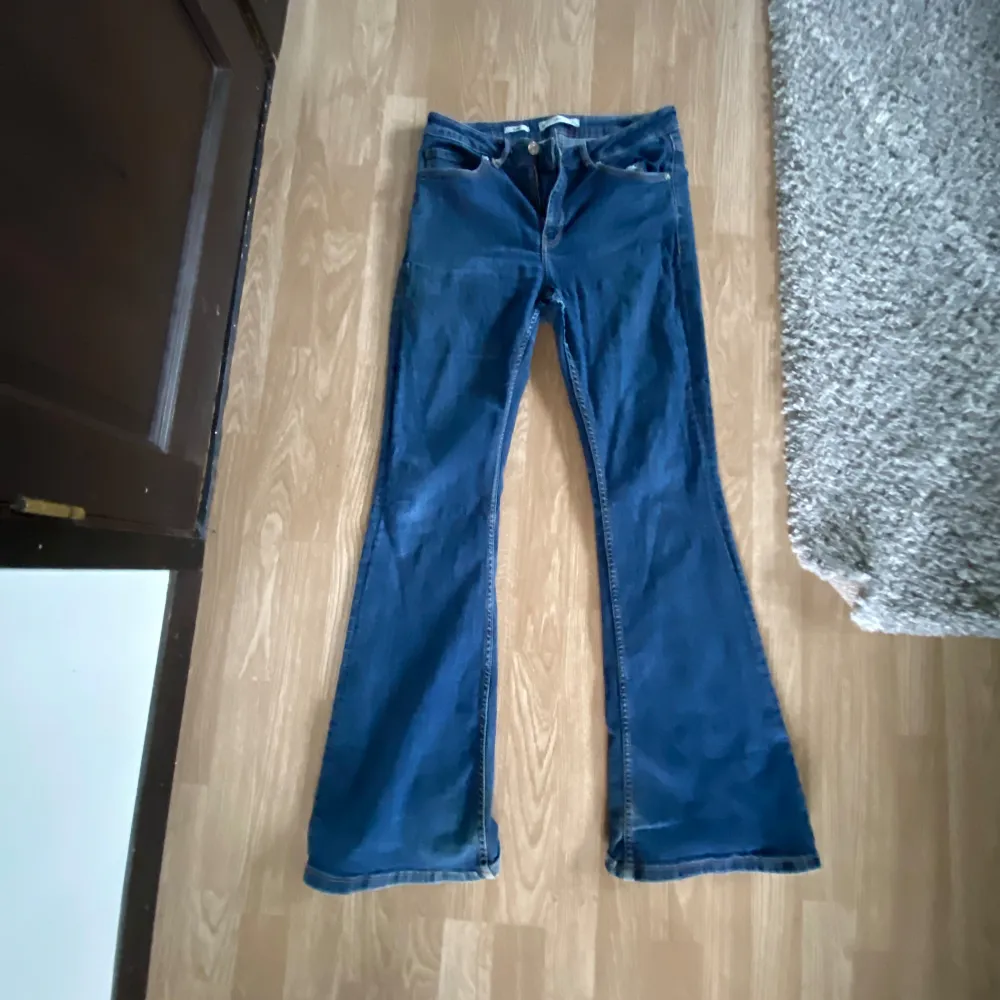 Blå stretshiga mango jeans i flaire modellen. Lite slitage och välsydda hål. . Jeans & Byxor.