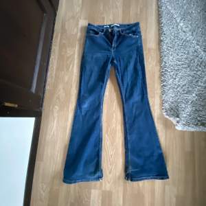 Blå stretshiga mango jeans i flaire modellen. Lite slitage och välsydda hål. 