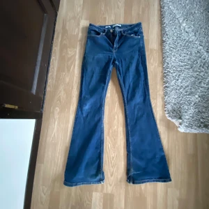 Blå flare jeans från MNG - Blå stretshiga mango jeans i flaire modellen. Lite slitage och välsydda hål. 