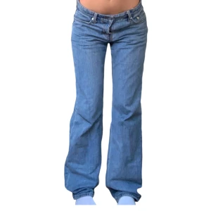 Weekday Jeans - Säljer ett par snygga blå jeans från Weekday i modellen Arrow Low Straight. Jeansen är lågmidjade. Notera att de är lite slitna längst ner, men det är inget man tänker på när man har på sig de.