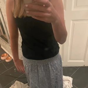 Blommig lång kjol  - Jättefin blå lång kjol/ klänning beroende på hur man vill ha den. Aldrig använd och inget slitage. Pris kan diskuteras vid snabb affär💗