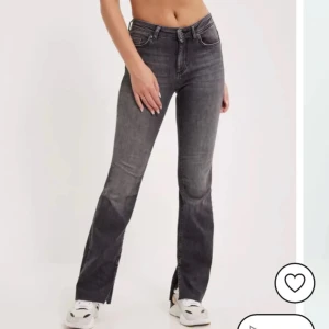 Grå bootcut jeans - Jag säljer dessa grå-svarta bootcut jeansen med slits vid benen som är köpte från Nelly men med märket only. Mjuka och stretchiga:)