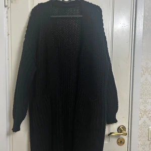 Svart lång cardigan  - Svart lång cardigan perfekt till hösten. Håller dig varm inför det kalla vädret och är helt i nyskick. 