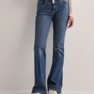 Blå bootcut jeans - Snygga blåa bootcut jeans från Nelly med snygga sömmar back på fickorna. Storlek 36, dem är i stretchigt material. Använd 2 ggr. Nypris 700kr 