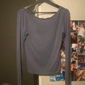Mörkblå långärmad backless topp från Gina Tricot - Säljer en stilren mörkblå långärmad backless topp från Gina tricot sista bilden kan man se en fläck som tyvärr ej går bort men jag själv tycker inte att den syns så mycket 