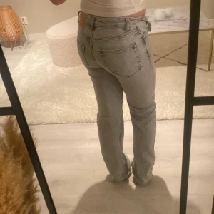 Grå jeans mid waist  - Säljer ett par grå jeans med rak passform och midwaist.. De har klassiska femficksdetaljer och en dragkedja framtill. Bra skick inte andvänt