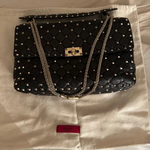 Valentino Garavani rockstud spike bag - Säljer min valentino rockstud spike bag large eftersom den tyvärr inte kommer till användning. Den är i superbra skick och kommer även med dustbag.  Jag kan frakta men även mötas upp i Stockholm. 