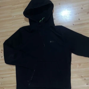 Boss kofta - Säljer en stilren svart hoodie från boss med dragkedja framtill. Perfekt för en avslappnad look. Den har en klassisk passform och en praktisk huva köpt för 2300kr 