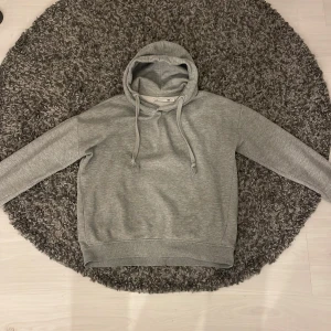 Grå hoodie från lager 157 - Säljer en bekväm grå hoodie från lager 157 i storlek S. ribbade muddar vid ärmslut och nederkant. Perfekt för en avslappnad stil.