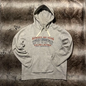 Ralph Lauren hoodie  - Säljer denna gråa vintage Ralph Lauren hoddien med tryck på framsidan. Den har ett retro tryck på framsidan vilket ger den en stilren look. Skriv om ni undrar något!