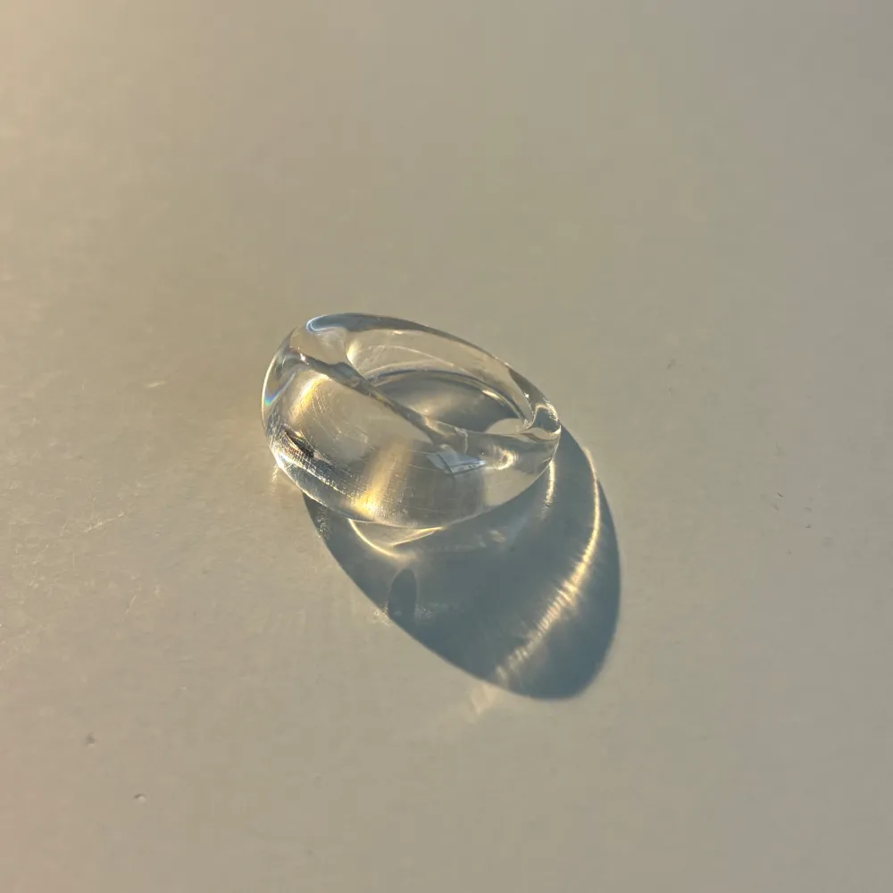 Snygg och stilren transparent ring som passar perfekt för en minimalistisk look. Ringen har en slät och rundad design som ger en modern känsla. Perfekt för att komplettera din outfit med en subtil touch av elegans.. Asusteet.