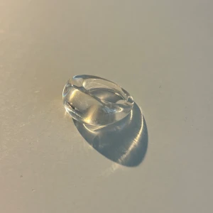 Transparent ring - Snygg och stilren transparent ring som passar perfekt för en minimalistisk look. Ringen har en slät och rundad design som ger en modern känsla. Perfekt för att komplettera din outfit med en subtil touch av elegans.