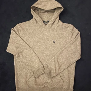 Grå Ralph Lauren Hoodie - Säljer min superfeta gråa Ralph Lauren hoodie då den tyvärr har blivit för liten. Den är i väldigt bra skick, 9/10. På bilden är jag 180cm, men som jag sa passar den litet på mig! Svarar snabbt på alla frågor💯Pris kan diskuteras!