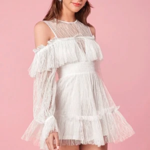 Studentklänning 💕 - Säljer en slutsåld vit spetsklänning med volanger och offshoulder-design ifrån enchant. Perfekt till studenten! Aldrig använd. 