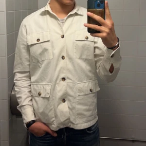 Overshirt krämvit - Skön övershirt/skjorta som är för stor för mig. Sparsamt använd. (OBS OSTRYKEN, DÄRAV SKRYNKLIG) köpt i Italien för 3000kr.  Defekter: översta knappen saknas, samt en sminkfläck under kragen på ryggen (se bild på sista sliden)