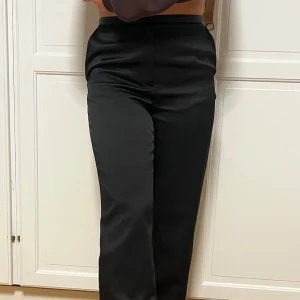 Svarta satin kostymbyxor - Säljer dessa vida svarta kostymbyxor i satin med rak passform. Dem är lite glansiga och är perfekta att klä upp eller ner🖤 Storlek 38 men funkar även för storlek 36! Dem är från HM men är slutsålda, nypris: 399kr