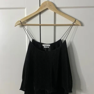 Svart ribbad linnetopp från Reserved - Den sitter ganska tajt så om man har stor byst kan den sitta lite tajtare vid bröstet. Snygg svart ribbad linnetopp från Reserved med tunna axelband. Perfekt för en stilren look. Tillverkad i Turkiet. En pytteliten tråd som har gått ut led där nere men inget särskilt man tänker på så.