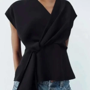 Svart omlottopp - Bra skick, den är i s men passar folk som har xs och s. 