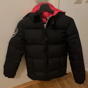 Dbrand vinterjacka - Säljer en assnygg dbrand jacka svart dunjacka med rosa foder och huva. Jackan har en dragkedja framtill. Perfekt för kalla dagar när du vill hålla dig varm och snygg. Skriv om du har fler frågor eller vill ha fler bilder🖤💖(pris går att diskutera)