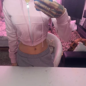 Rosa croppad hoodie från Divided - Säljer en söt rosa croppad hoodie från h&m. Den har en dragkedja framtill och en mysig huva med snören. 🩷