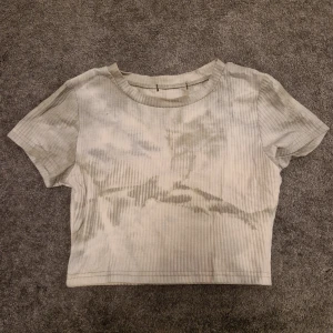 Grön ribbad croppad topp - Säljer en stilren grön ribbad croppad topp med korta ärmar. Perfekt för en avslappnad look. Toppen har en mjuk och bekväm passform.