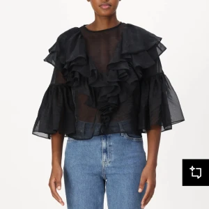 Svart blus med volanger - Snygg svart blus med volanger framtill och trekvartsärmar. Perfekt för en stilfull look. Perfekt för festliga tillfällen.  Lappar och allt finns kvar, de var bara jag som glömde lämna tillbaka då den var lite för liten för mig!