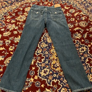 Jeans från True Religion - Snygga jeans från True Religion i en klassisk blå färg. De är Low Waist och straight och har midjemåttet 38 cm rakt över. Sänkt pris vid snabb affär❤️