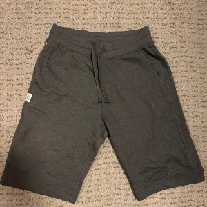 Mörkgrå shorts från Everlast - Snygga mörkgrå shorts från Everlast med snörning i midjan. Perfekta för en avslappnad stil. De har en bakficka och är tillverkade i ett mjukt material för extra komfort.