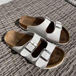 Vita sandaler - Vita sandaler från Duffy i storlek 38. Har ett ljusgrönt märke på vänster sko insida, se bild. 