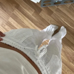 Vita linnebyxor med snörning - Säljer ett par superbekväma vita linnebyxor. De är lågmidiade med en elastisk midja och snörning för bästa passform. Byxorna har två stora fickor fram och en bakficka. Perfekta för sommarens varma dagar!
