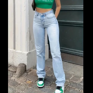 Ljusblå jeans med hög midja - Säljer ett par snygga ljusblå jeans med hög midja. De är i en straight fit och har en klassisk femficksdesign med dragkedja och knapp framtill. Perfekta för både vardag och fest! 🦋