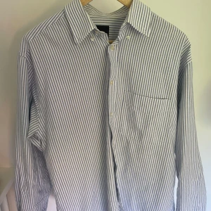 Två skjortor  - Båda är i bra skick, den blåa är lite mer slitten en den randiga, båda i storlek M Säljer en för 100kr