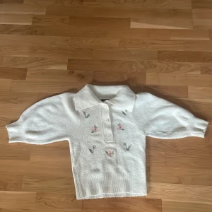 Fin stickad tröja med små blommor - En stickad tröja i fint skick med små blommor