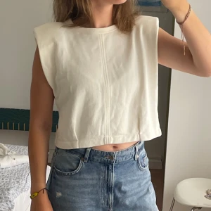 Vit croppad topp - Vit snygg croppad topp med vadderade axlar från Zara! Storlek M